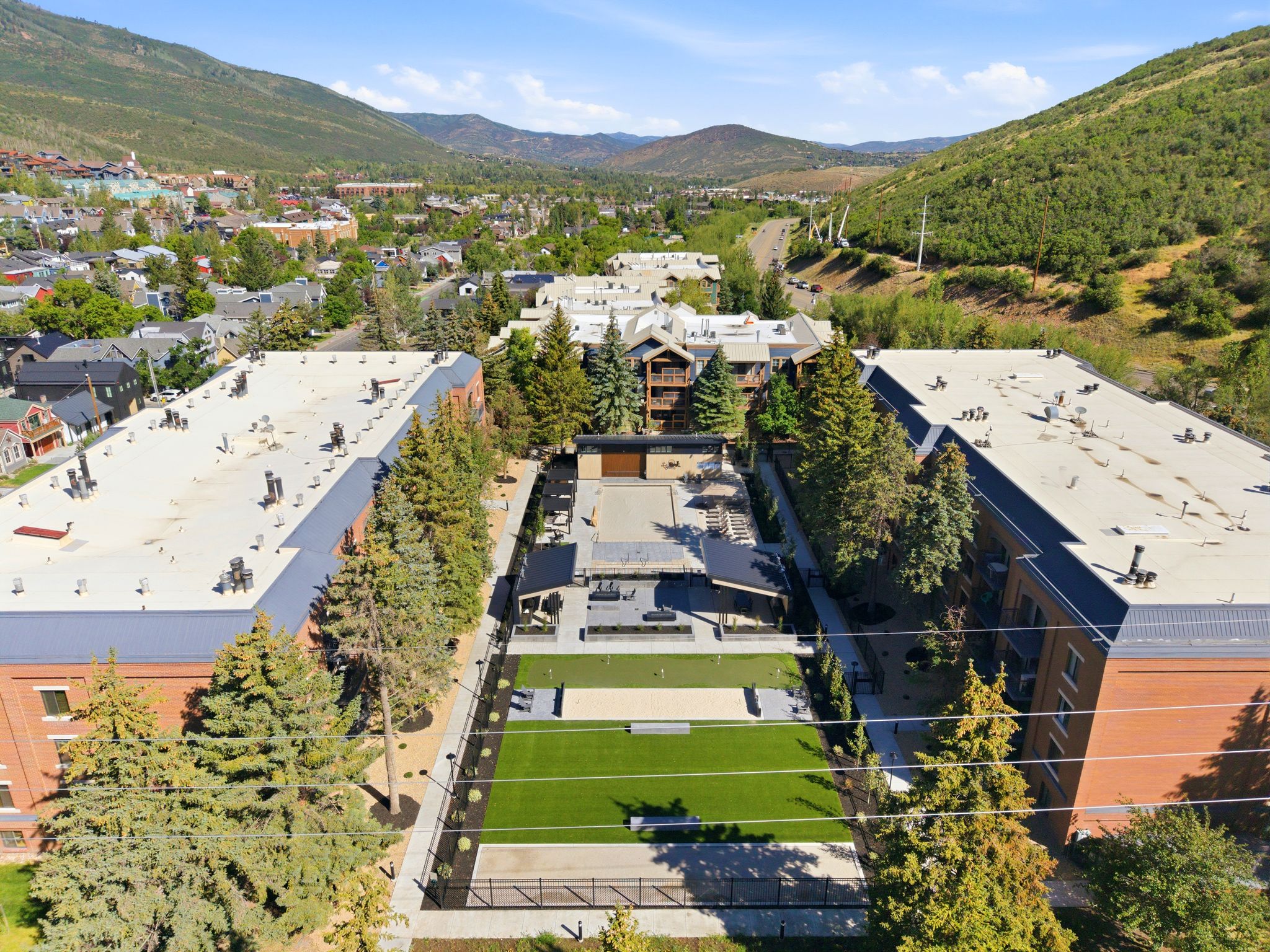 Expansive outdoor amenity space featuring artificial turf, structured landscaping, and paved pathways