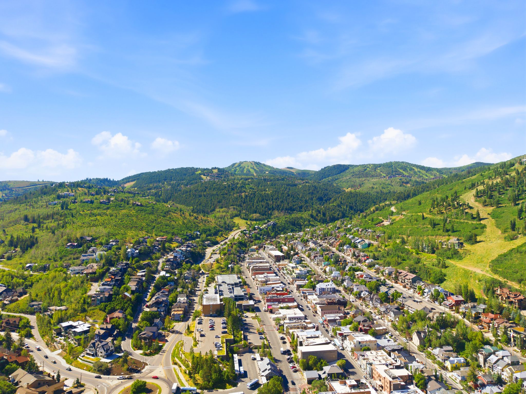 Panoramic aerial capture showcasing a vibrant mountain town nestled amidst verdant hillsides