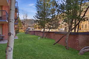 View of green lawn featuring a balcony
