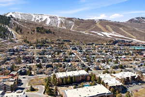Aerial overview of property's location with a mountain backdrop and nearby suburban area