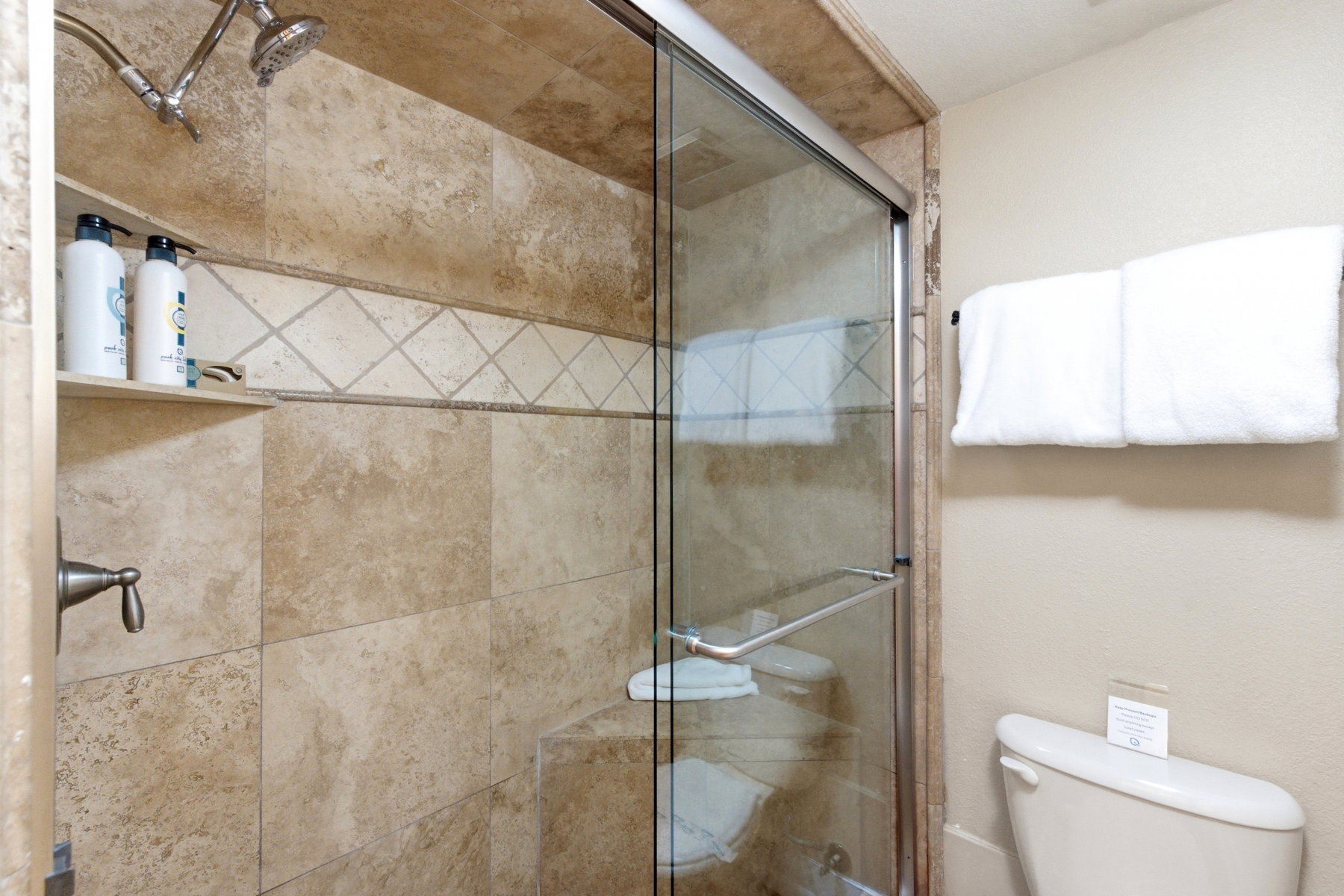 Full bathroom featuring a stall shower and toilet