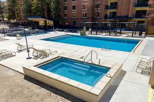 Community pool featuring a patio area and a hot tub