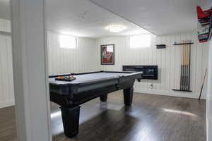 Game room featuring billiards, dark wood finished floors, and wood walls
