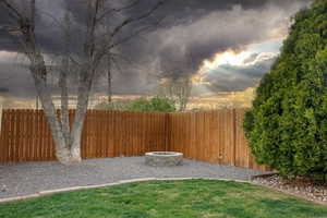 Yard at dusk featuring a fire pit and a fenced backyard