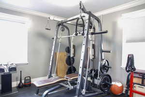 Exercise area featuring rubber floors and ornamental molding