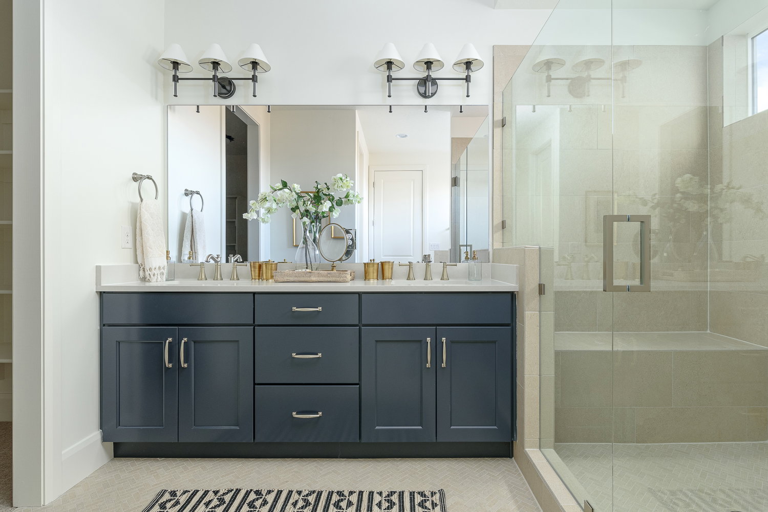Full bath with double vanity and a shower stall