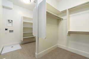 Walk in closet with light colored carpet