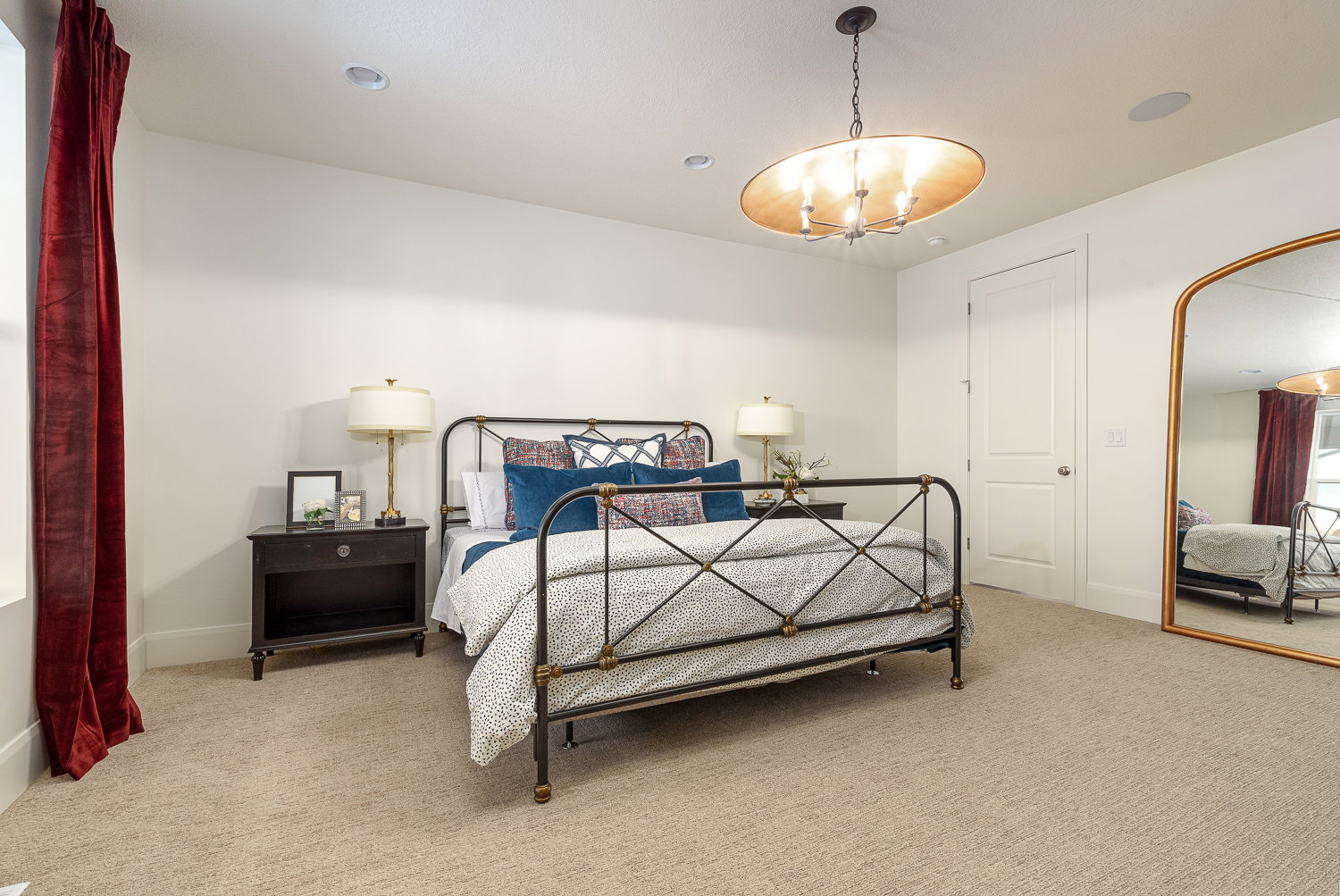 Bedroom with arched walkways, light colored carpet, and hanging lights