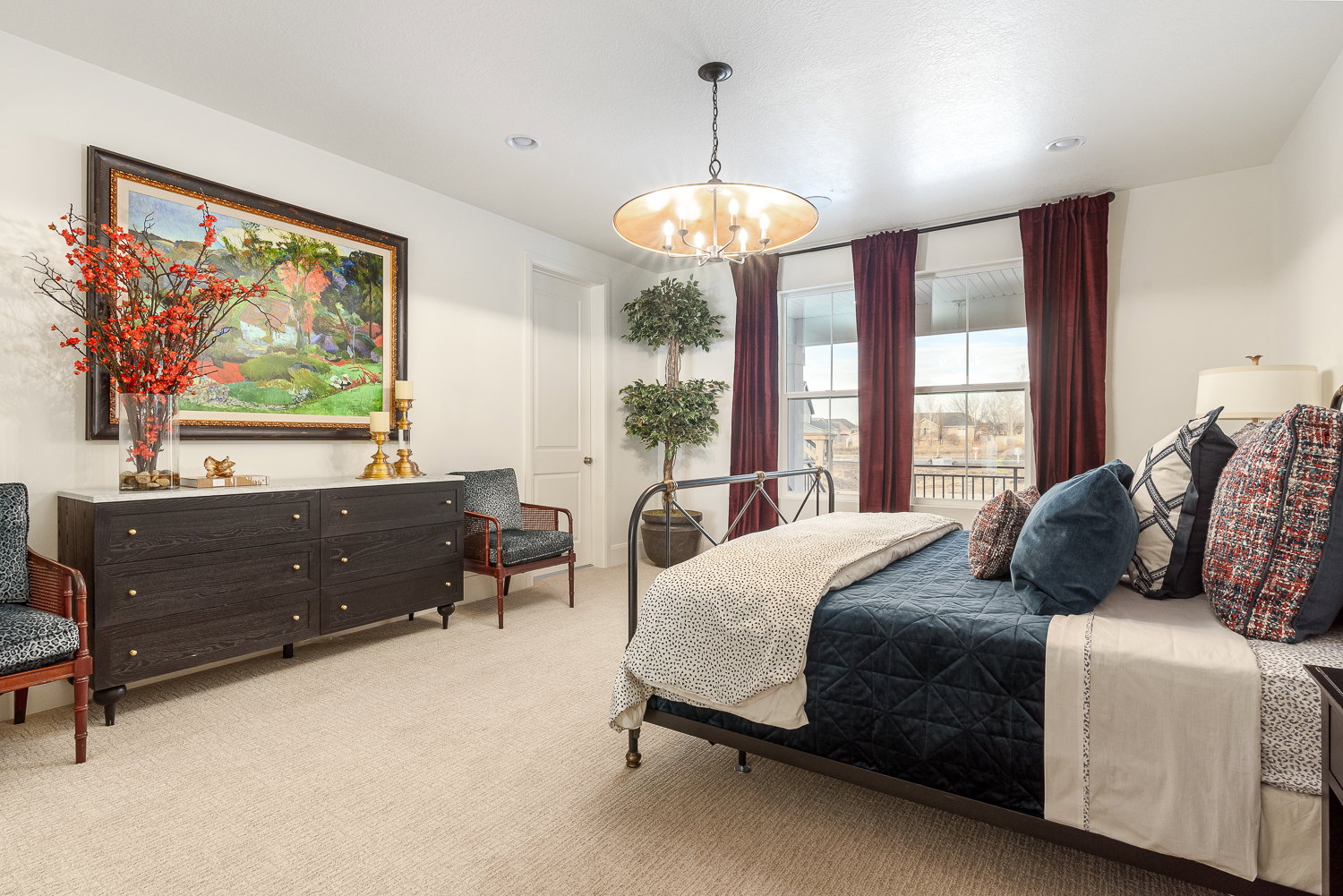 Bedroom with light carpet and hanging lights