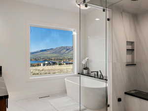 Full bathroom featuring a freestanding tub, vanity, and a water and mountain view
