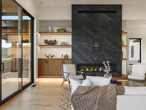 Living area featuring a high end fireplace and light wood-style floors