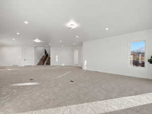 Empty room with light colored carpet and recessed lighting