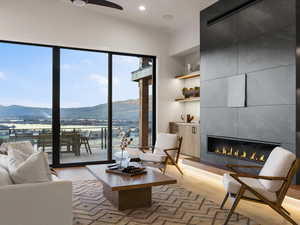 Living area featuring a mountain view, light wood-style floors, a ceiling fan, a tile fireplace, and recessed lighting
