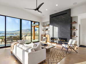 Living area featuring a ceiling fan, hardwood / wood-style floors, recessed lighting, lofted ceiling, and a fireplace