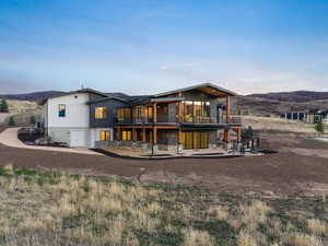 Back of house featuring a mountain view and a balcony