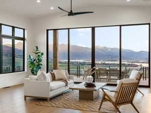 Living room with a mountain view, recessed lighting, ceiling fan, light wood-type flooring, and lofted ceiling
