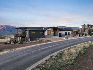 View of front of house featuring a mountain view, a standing seam roof, and stone siding