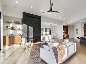 Living room featuring a ceiling fan, recessed lighting, light wood-style flooring, and a fireplace