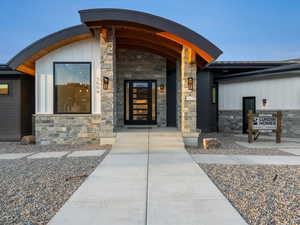 Entrance to property with stone siding and board and batten siding