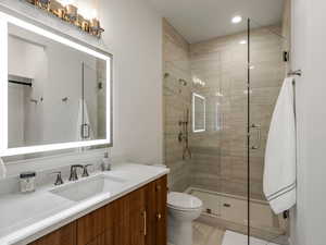 Full bath featuring vanity, a stall shower, and recessed lighting