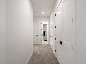 Hallway featuring light carpet and recessed lighting