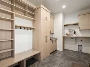 Mudroom with recessed lighting and dark marble finish flooring