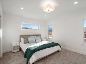 Carpeted bedroom with multiple windows and recessed lighting