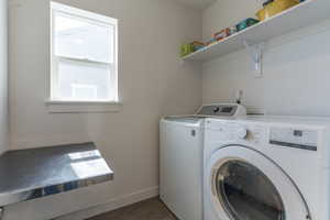Laundry room with dark wood-style floors and washing machine and dryer