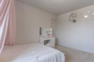 Bedroom with light colored carpet and baseboards