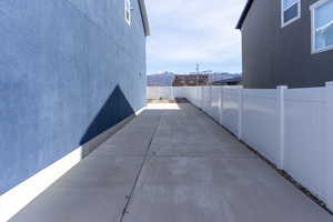 View of side of property featuring a mountain view, a fenced backyard, and a patio area