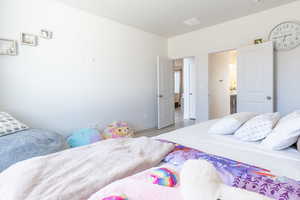 Bedroom with wood finished floors and connected bathroom