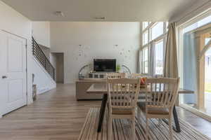 Dining area featuring light wood-type flooring and a high ceiling