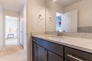 Bathroom featuring vanity and light carpet