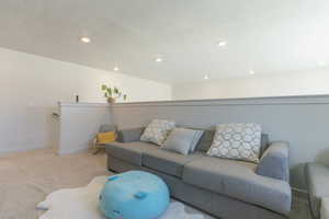 Living room with light colored carpet and recessed lighting