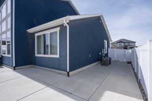 View of property exterior featuring a gate, a fenced backyard, and stucco siding