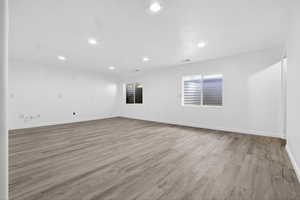 Empty room with light wood-style floors and recessed lighting