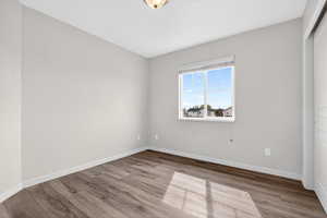 Spare room featuring light wood-type flooring and baseboards