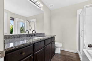 Full bathroom with vanity, a stall shower, and dark wood-type flooring