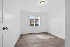 Unfurnished room featuring light wood finished floors and baseboards
