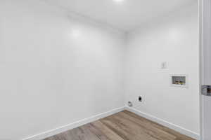 Laundry room featuring hookup for a washing machine, light wood finished floors, and electric dryer hookup