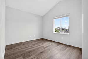 Unfurnished room with lofted ceiling and light wood finished floors