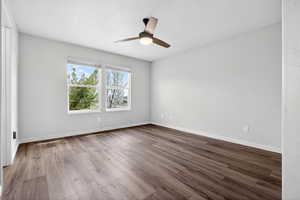 Spare room with dark wood finished floors and ceiling fan