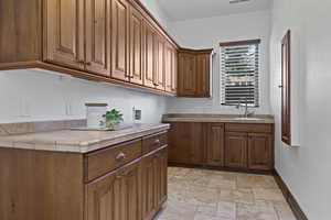 Laundry room featuring light stone finish floors, cabinet space, and washer hookup