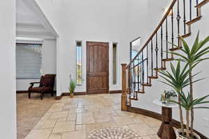 Entryway featuring stone tile floors and a high ceiling