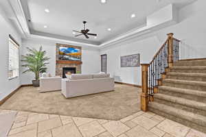 Living area featuring stone tile flooring, a fireplace, ceiling fan, and recessed lighting