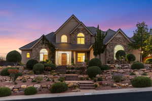 Traditional-style house featuring stone siding, stucco siding, and a tile roof