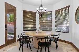 Dining space featuring stone tile flooring and hanging lights