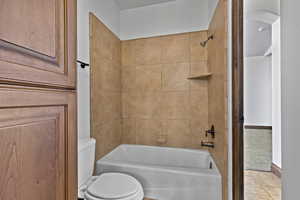 Bathroom with bathing tub / shower combination, tile patterned floors, and carpet
