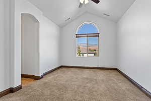 Unfurnished room with light colored carpet, ceiling fan, a mountain view, and arched walkways