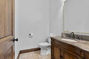 Half bath with vanity and stone tile floors